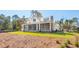 Exterior view of a large home with a screened-in porch and well-maintained yard in a wooded area at 116 Peninsula Dr, Ravenel, SC 29470