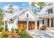 Exterior of a two-car garage with wooden doors, a light-colored facade, and a well-manicured yard at 116 Peninsula Dr, Ravenel, SC 29470