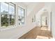 Bright hallway with hardwood floors, white walls, and large windows offering beautiful outdoor views at 116 Peninsula Dr, Ravenel, SC 29470