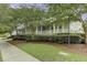 Exterior view of White Gables Club featuring a covered porch surrounded by lush landscaping and greenery at 123 Hyacinth St, Summerville, SC 29483