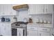 Detailed kitchen view with white cabinets, stainless steel appliances, marble counters, and decorative backsplash at 123 Hyacinth St, Summerville, SC 29483