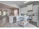 Bright, open kitchen with white cabinets, a blue island, and stainless steel appliances, seamlessly flowing into the living area at 123 Hyacinth St, Summerville, SC 29483