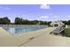 Community pool with lounge chairs and umbrellas, with greenery and a clubhouse in the background at 123 Hyacinth St, Summerville, SC 29483