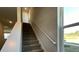 Carpeted staircase with white railing ascends to the next level, bathed in natural light from a nearby window at 135 Yarrow Way, Moncks Corner, SC 29461