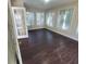 Sun-filled room with multiple windows, hardwood floors, and a door leading to the outdoors at 1391 Center Lake Dr, Mount Pleasant, SC 29464