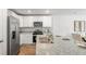 Modern kitchen features white cabinets, granite countertops, and stainless steel appliances with an open layout at 141 Yarrow Way, Moncks Corner, SC 29461