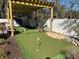 Backyard putting green with practice area, pergola, and natural stone accents for outdoor enjoyment at 1414 N Sherwood Dr, Charleston, SC 29407