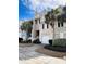 Inviting townhome exterior with a one car garage, complemented by lush landscaping and palm trees at 155 Winding River Dr, Johns Island, SC 29455