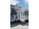 Inviting townhome exterior with a one car garage, complemented by lush landscaping and palm trees at 155 Winding River Dr, Johns Island, SC 29455
