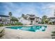Community pool surrounded by palm trees and townhouses, offering a refreshing and social space at 155 Winding River Dr, Johns Island, SC 29455