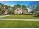 Inviting two-story home with tan siding, brick accents, and a lush green lawn under a clear blue sky at 177 Thousand Oaks Cir, Goose Creek, SC 29445