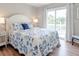 Bright bedroom with a blue-themed bedspread, white furniture and sliding glass doors to the outside at 2 Pelican Reach # Share 11, Isle of Palms, SC 29451