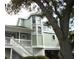 Exterior view of a two-story house with a white stair case leading up to the front porch at 2 Pelican Reach # Share 11, Isle of Palms, SC 29451