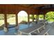 Outdoor pavilion with picnic tables for gatherings and a glimpse of the green grass and blue sky outside at 2 Pelican Reach # Share 11, Isle of Palms, SC 29451