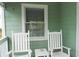 Inviting porch featuring rocking chairs and a small table, perfect for relaxing and enjoying the outdoors at 2 Pelican Reach # Share 11, Isle of Palms, SC 29451