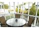 Screened in porch with a table and chairs and a view of the water and neighborhood at 2 Pelican Reach # Share 11, Isle of Palms, SC 29451