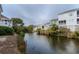 Water view of a canal surrounded by houses, trees, and shrubs on a cloudy day at 2 Pelican Reach # Share 11, Isle of Palms, SC 29451