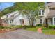 View of a white house with light yellow trim and a brick walkway leading to a small balcony and an orange door at 2 Townpark Ln # D, Charleston, SC 29412