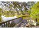 Scenic view of a tranquil lake from a wooden deck, surrounded by lush trees, creating a serene and picturesque setting at 2 Townpark Ln # D, Charleston, SC 29412