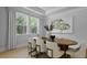A stylish dining room features large windows, wood floors and a large oval table at 202 Bilge Rd, Ridgeville, SC 29472