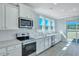 Modern kitchen with stainless steel appliances, white cabinets, and light countertops at 203 Bilge Rd, Ridgeville, SC 29472