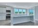 Bright kitchen features white cabinetry, stainless appliances, and an island with light countertops at 203 Bilge Rd, Ridgeville, SC 29472