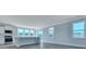 Bright living room adjacent to a kitchen with stainless appliances and white cabinetry, with hardwood floors throughout at 203 Bilge Rd, Ridgeville, SC 29472