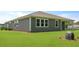 A gray home exterior with large windows and green grass, showcasing a modern, inviting design at 206 Bilge Rd, Ridgeville, SC 29472