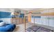A spacious bedroom is decorated with light-wood furnishings, a whimsical art piece, and a cozy blue chaise lounge at 210 Bilge Rd, Ridgeville, SC 29472