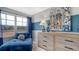 Inviting bedroom showcases a plush blue lounge chair, a light wood dresser, and a fun dog-themed art piece at 210 Bilge Rd, Ridgeville, SC 29472
