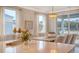 An elegant dining area features a chic chandelier, stylish decor, and bright, natural light from surrounding windows at 210 Bilge Rd, Ridgeville, SC 29472