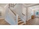 Hallway with staircase and wood floors that leads to the home's front entrance at 210 Bilge Rd, Ridgeville, SC 29472