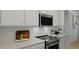 Modern kitchen features white cabinetry, stainless steel microwave and oven with subway tile backsplash at 212 Bilge Rd, Ridgeville, SC 29472