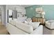 Beautiful living room features white sofa and stylish bar area with mini fridge and light blue accent wall at 212 Bilge Rd, Ridgeville, SC 29472