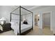 Bright main bedroom boasts a four-poster bed, neutral decor, ensuite bath, and walk-in closet at 212 Bilge Rd, Ridgeville, SC 29472