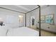Bright main bedroom featuring a four-poster bed, access to ensuite bathroom, and a glimpse of the kitchen at 212 Bilge Rd, Ridgeville, SC 29472