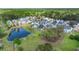 High-angle view of a neighborhood featuring a pond, lush trees, and orderly streets nestled within a green landscape at 215 Center Hill Ct, Summerville, SC 29485