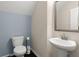 Stylish half bath featuring blue accent wall, pedestal sink, and modern fixtures at 215 Center Hill Ct, Summerville, SC 29485