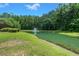 Picturesque pond with a fountain, surrounded by green lawns and dense trees, creating a peaceful setting at 215 Center Hill Ct, Summerville, SC 29485