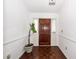 Inviting foyer with hardwood flooring, white walls, and a wooden front door with decorative plant at 2441 Hansard Dr, North Charleston, SC 29406