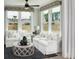 Cozy living room features white furniture, a ceiling fan, and large windows showcasing the backyard at 267 Garden Gate Way, Summerville, SC 29486