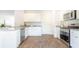 Spacious kitchen with stainless steel appliances, granite countertops, white cabinets, and wood-look flooring at 267 Wild Strawberry Ln, Moncks Corner, SC 29461
