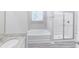 Bright bathroom featuring granite vanity, soaking tub and glass-enclosed shower at 277 W Smith St, Lincolnville, SC 29485