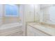 Bathroom with tub, shower, granite countertop vanity, and window with natural light at 277 W Smith St, Lincolnville, SC 29485
