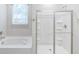 Bright bathroom featuring a glass-enclosed shower and separate soaking tub at 277 W Smith St, Lincolnville, SC 29485
