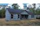 New construction shows classic home with dark roof and covered entry, surrounded by natural landscape at 277 W Smith St, Lincolnville, SC 29485