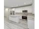 A bright kitchen features white cabinets, stainless steel appliances, granite countertops, and light-colored wood flooring at 277 W Smith St, Lincolnville, SC 29485