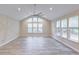 Bright living room with vaulted ceiling, modern flooring, large windows, and a contemporary ceiling fan at 277 W Smith St, Lincolnville, SC 29485