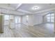 Open-concept living room with modern gray flooring, white cabinets, and lots of natural light at 277 W Smith St, Lincolnville, SC 29485