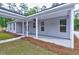 Inviting covered patio with gray siding, ceiling fan, and pathway, ideal for outdoor gatherings at 277 W Smith St, Lincolnville, SC 29485